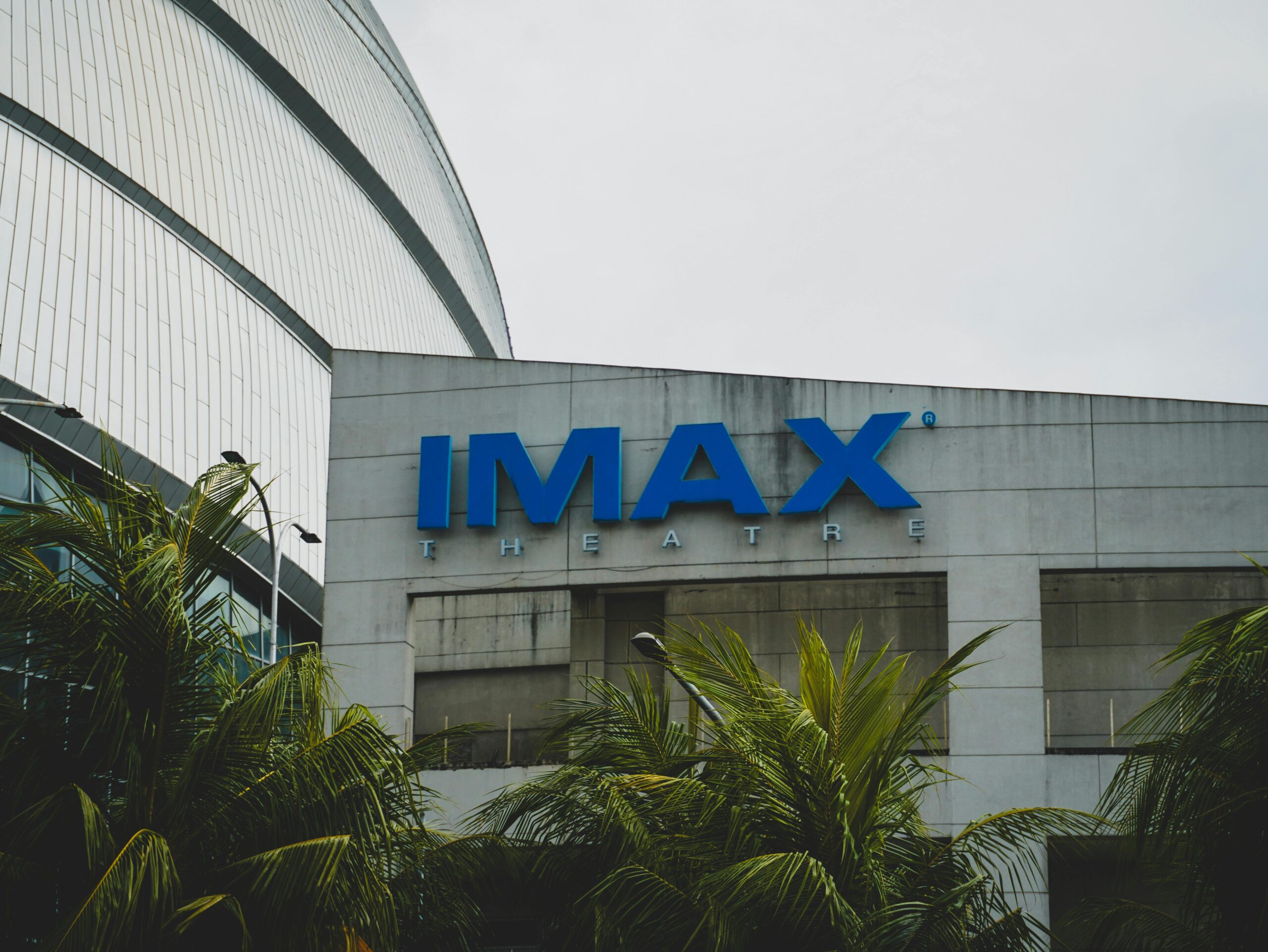 Exterior view of IMAX Theatre in Pasay City, Philippines with palm trees.