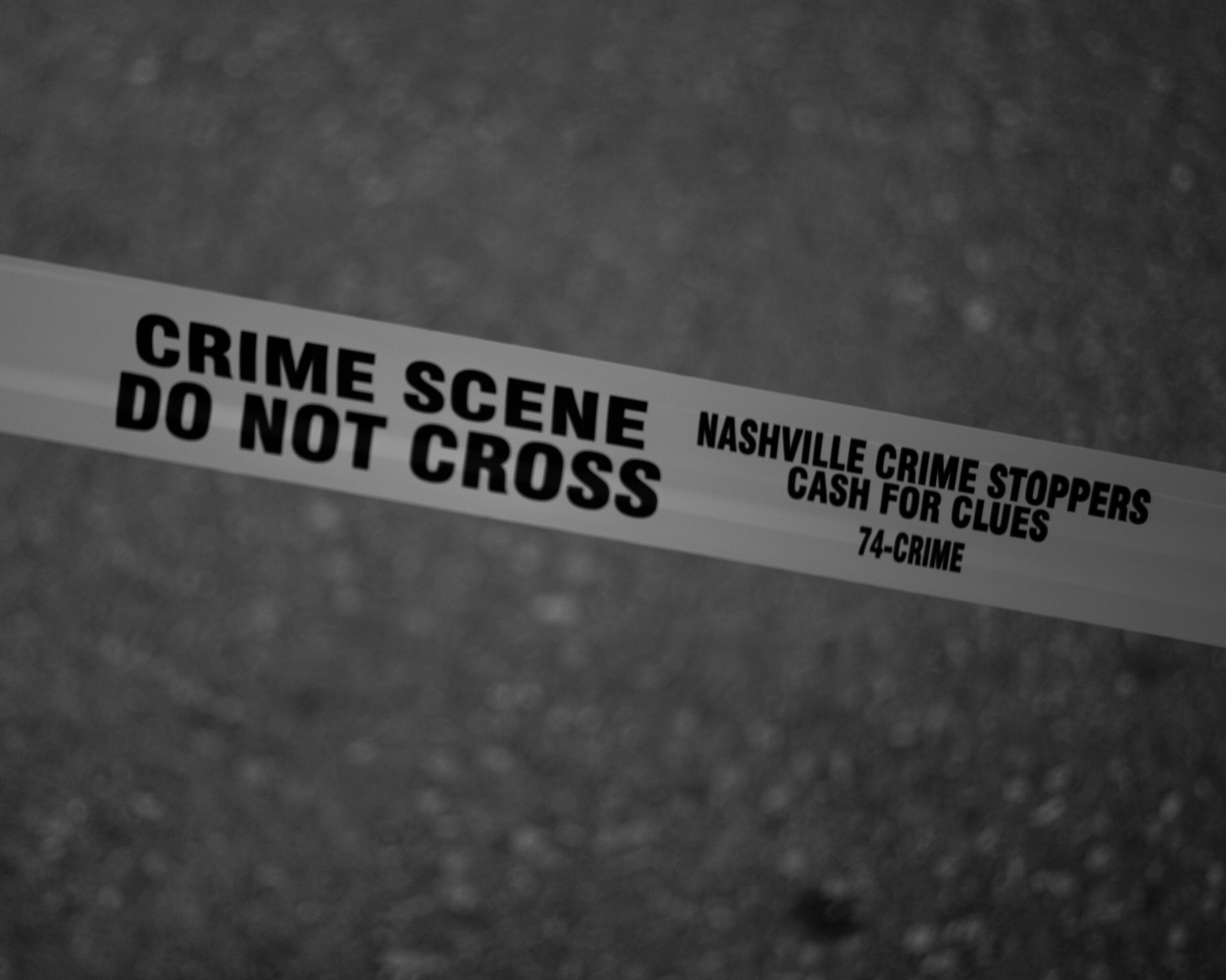 Black and white close-up of crime scene tape with Nashville text.