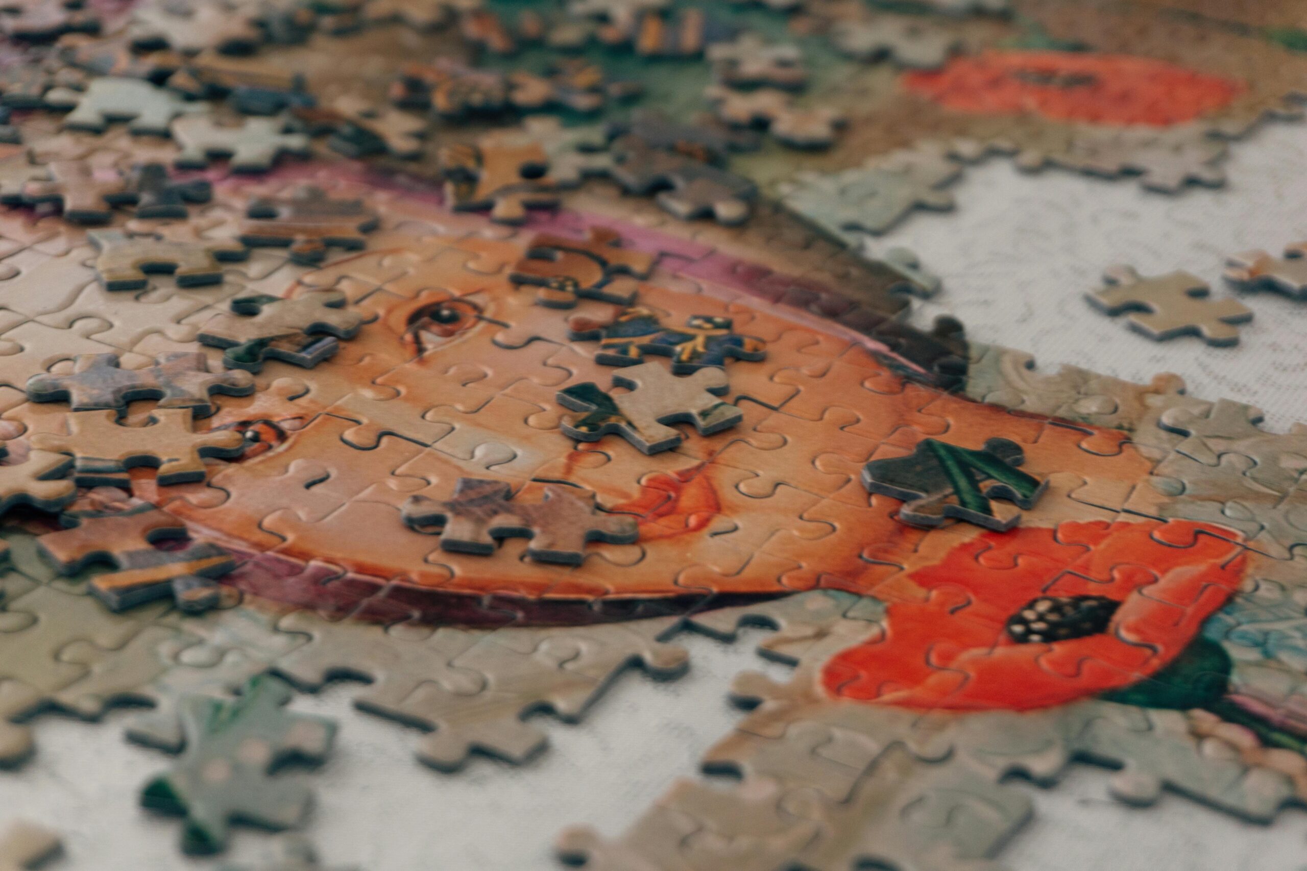A close-up view of an unfinished puzzle featuring a portrait, scattered pieces creating a playful, creative atmosphere.
