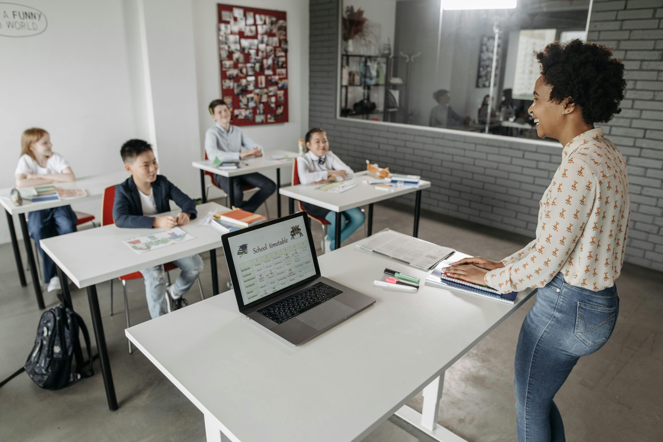 Teacher interacting with students in a modern classroom setting, fostering education.